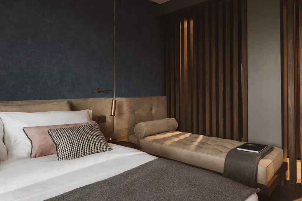 Camera da letto elegante e moderna con letto matrimoniale e chaise longue.