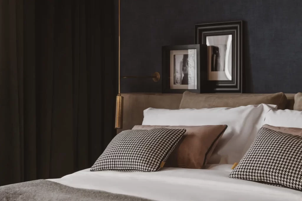Letto elegante con cuscini a quadretti e decorazioni minimaliste.