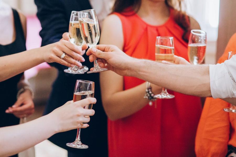 Persone che brindano con bicchieri di champagne a una festa.